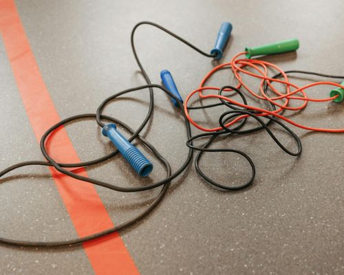 Hand gripping a jump rope handle in a gym